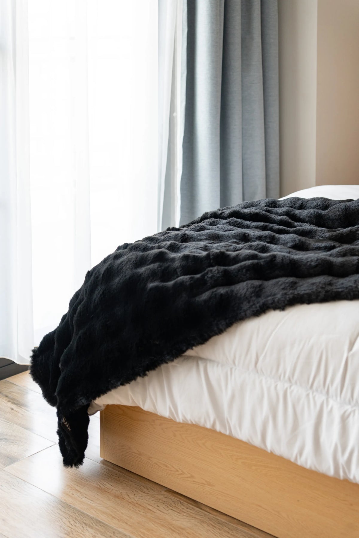 Cudds faux fur throw on a made bed