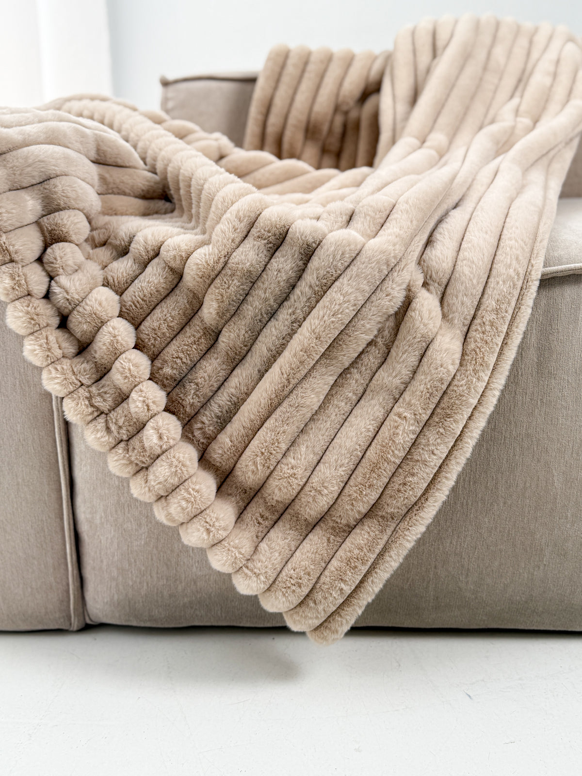 A Cudds fluffy throw on a sofa